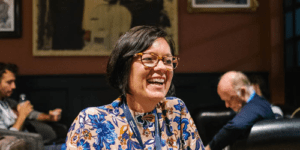 Lady with glasses and a patterned top laughing