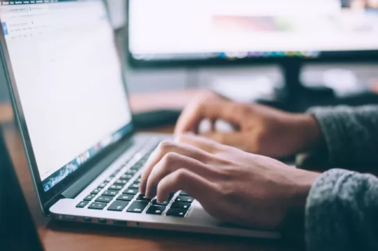 Male hands on laptop keyboard