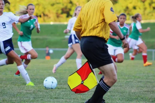 Girls playing football with ref